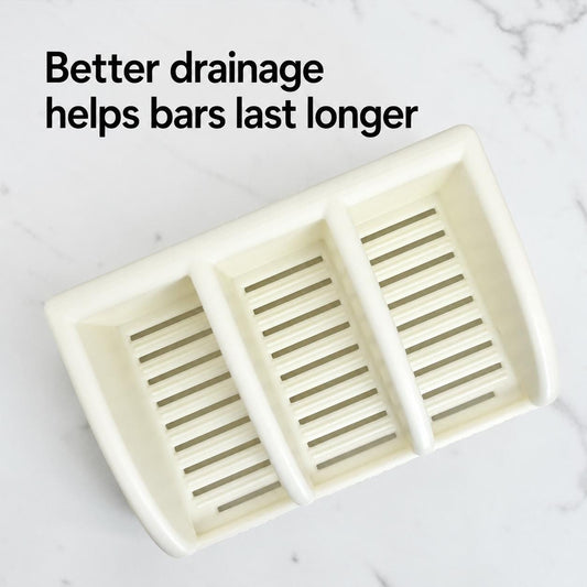 White soap dish with three compartments on a light gray background, text 'Better drainage helps bars last longer' above.