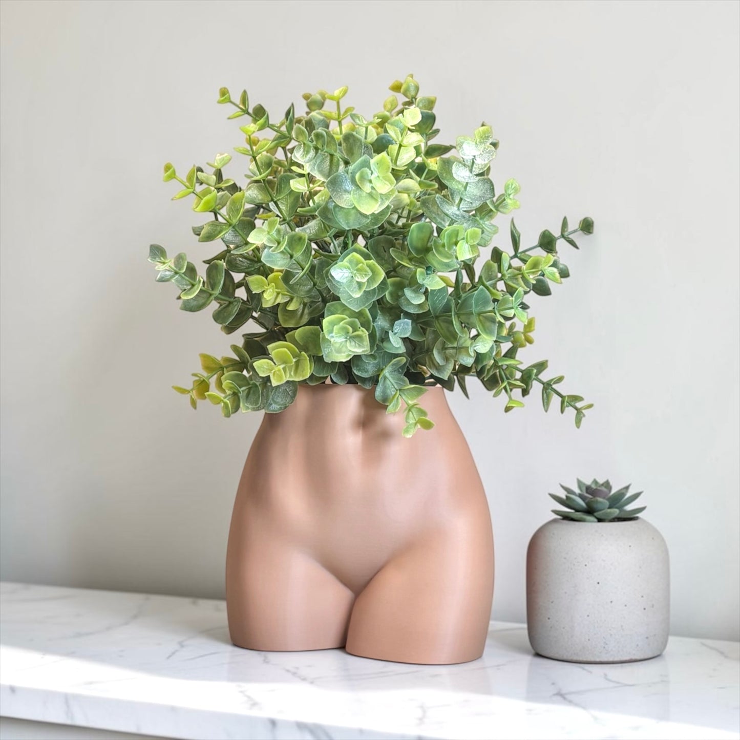 Latte Brown Vase shaped like a female torso with green plant on a marble surface