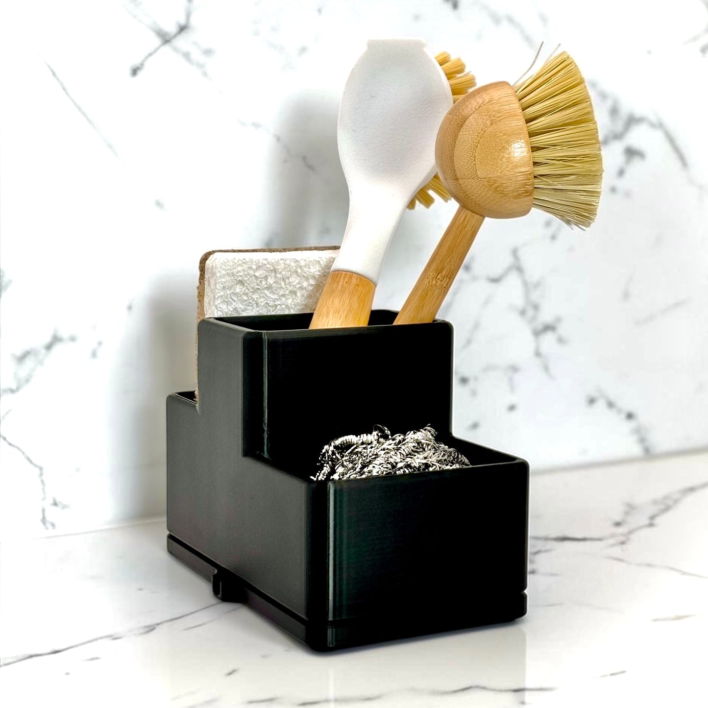 Black multi-tiered organizer with kitchen utensils on a marble surface