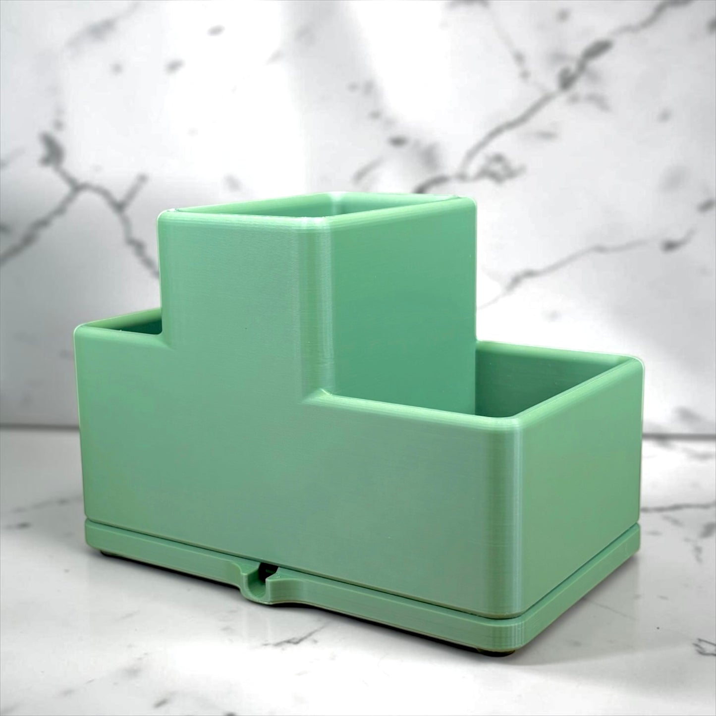 Green rectangular sink caddy on a marble surface