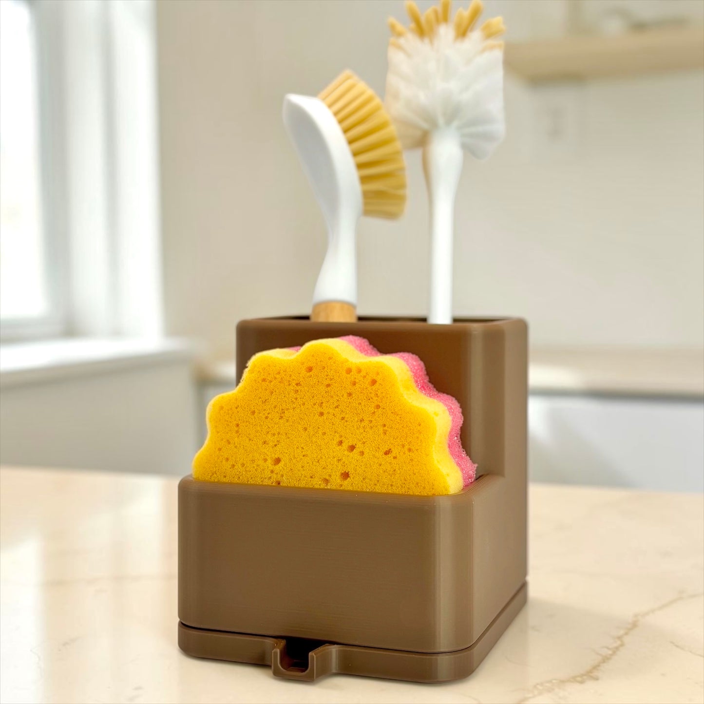Brown utensil holder with a sponge and brushes on a kitchen counter.