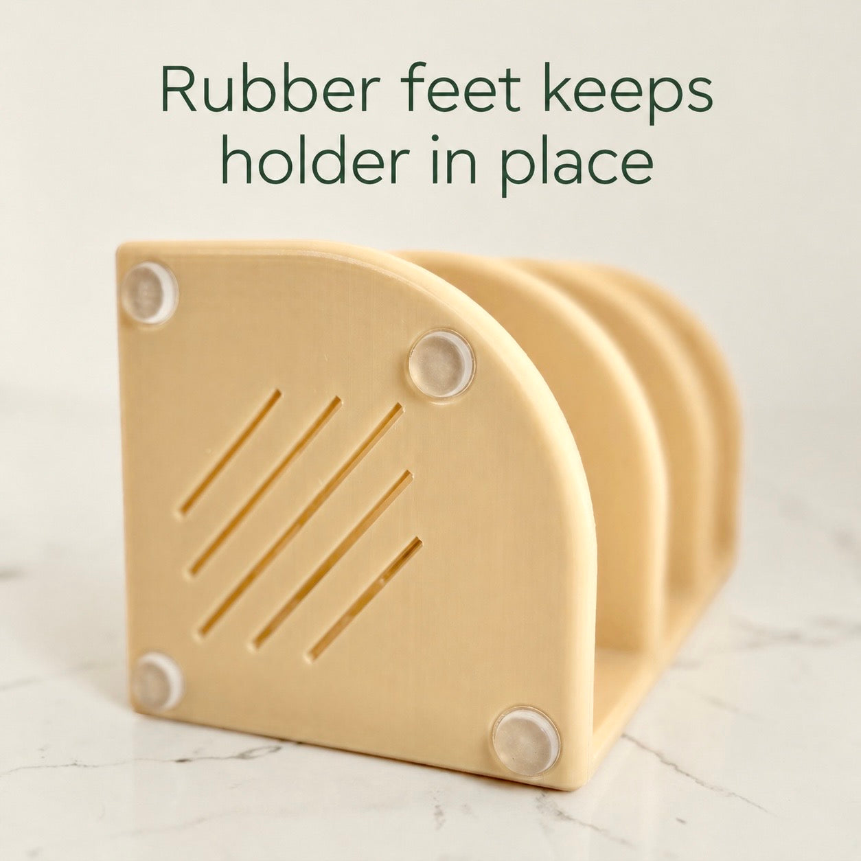Beige holder with rubber feet on a marble surface, text 'Rubber feet keeps holder in place'.