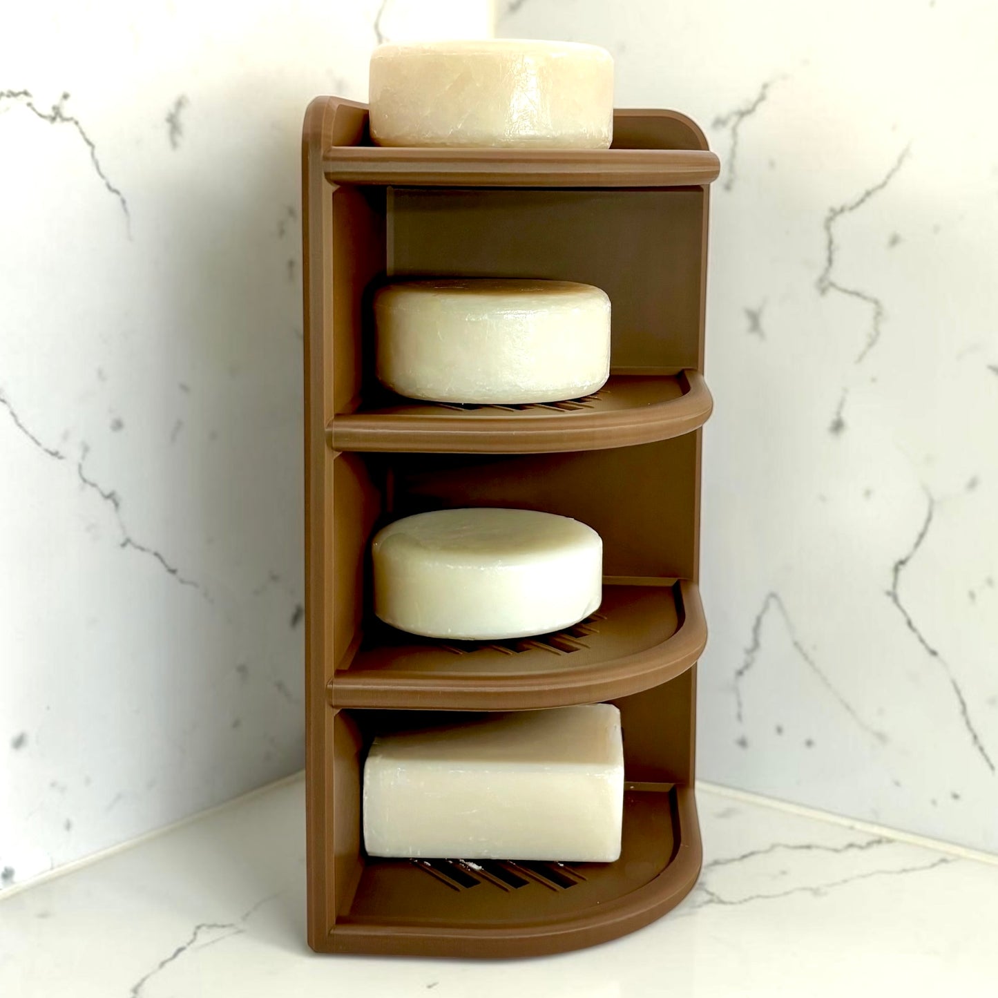Brown corner shelf with soap bars against a marble wall.