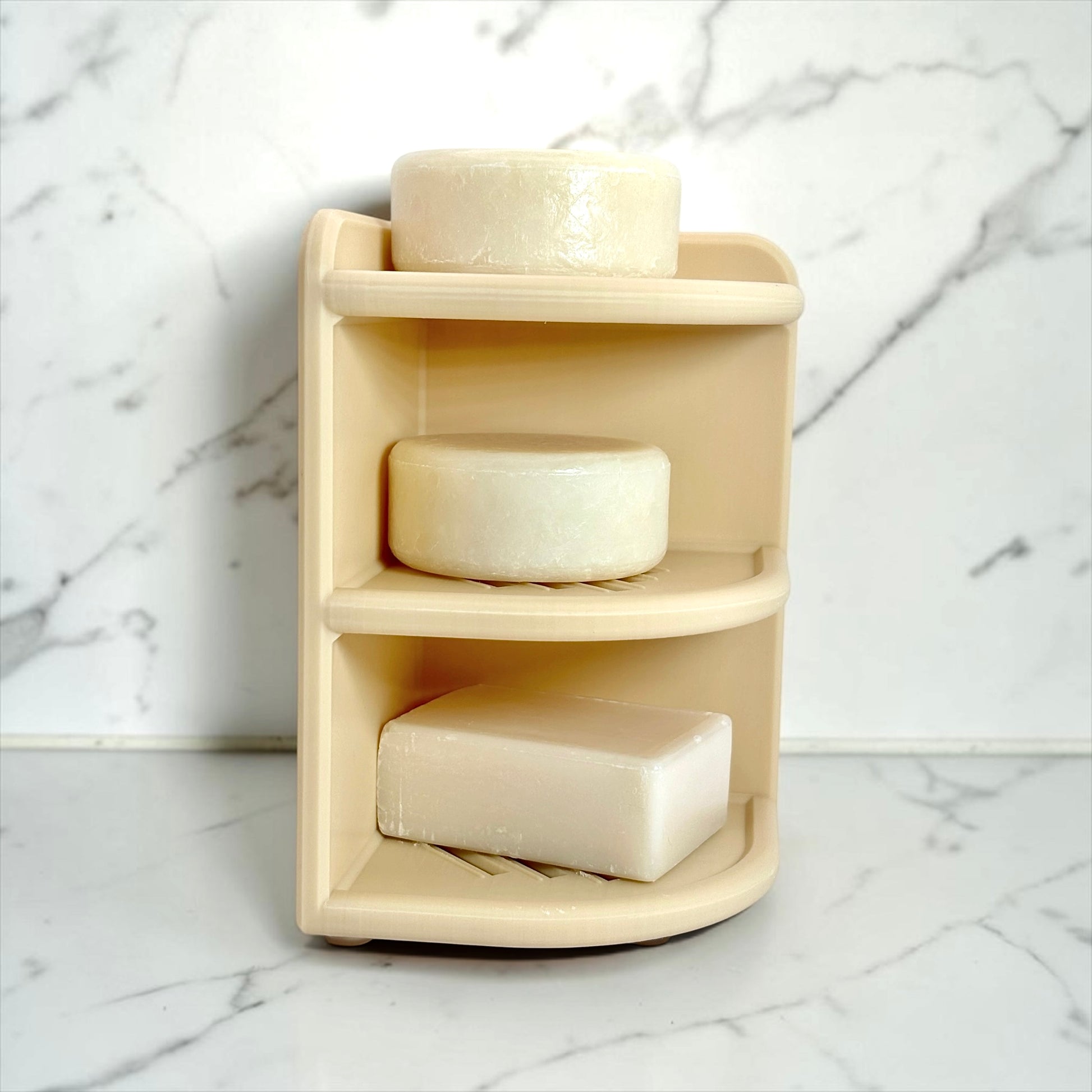 Beige corner shelf with three soap bars on a marble background