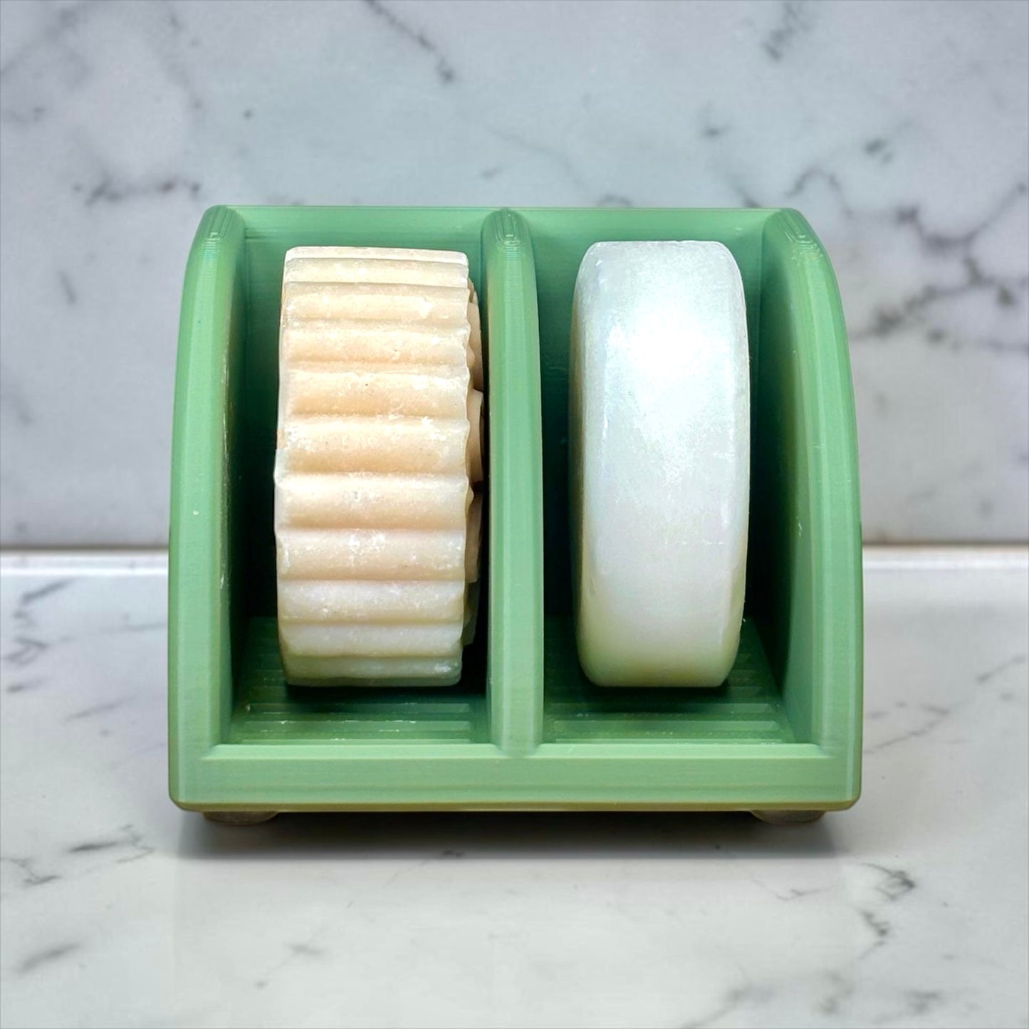 Olive Green soap holder with two bars of soap on a marble surface