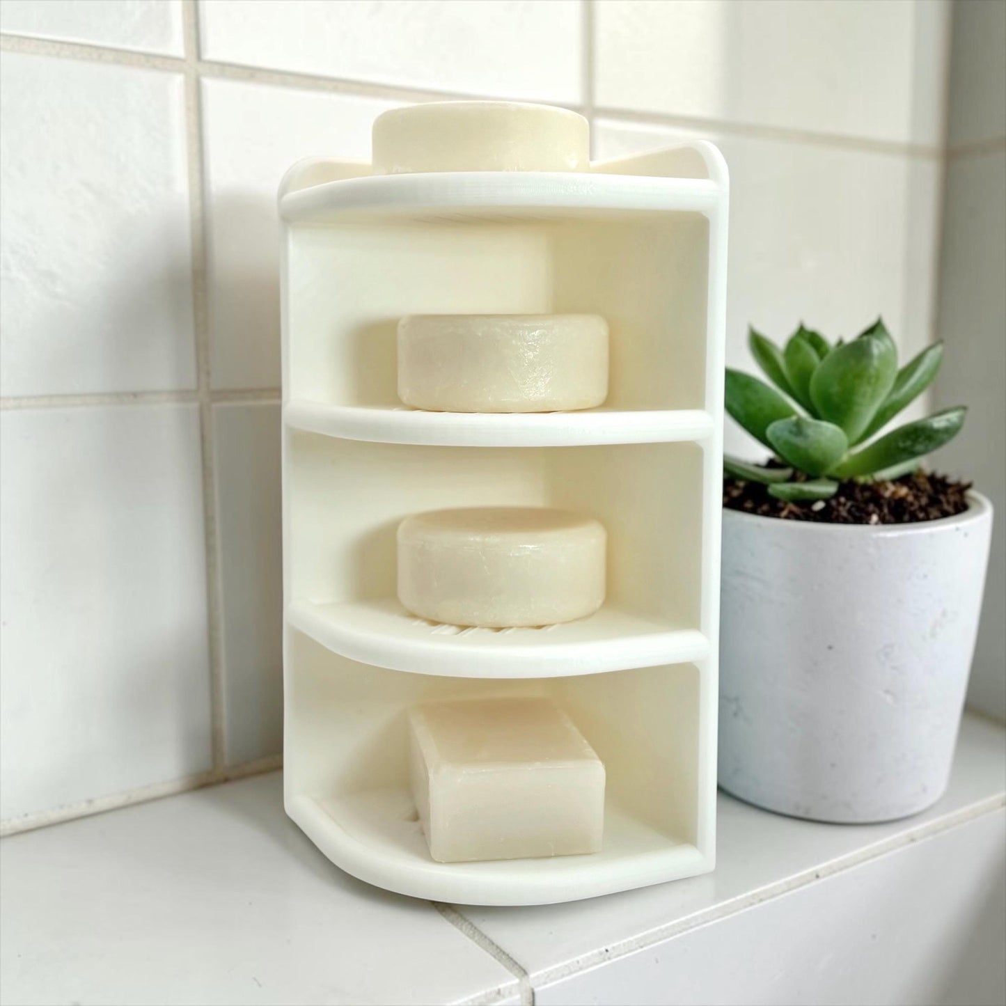 Corner shelf with soap bars on a tiled bathroom wall