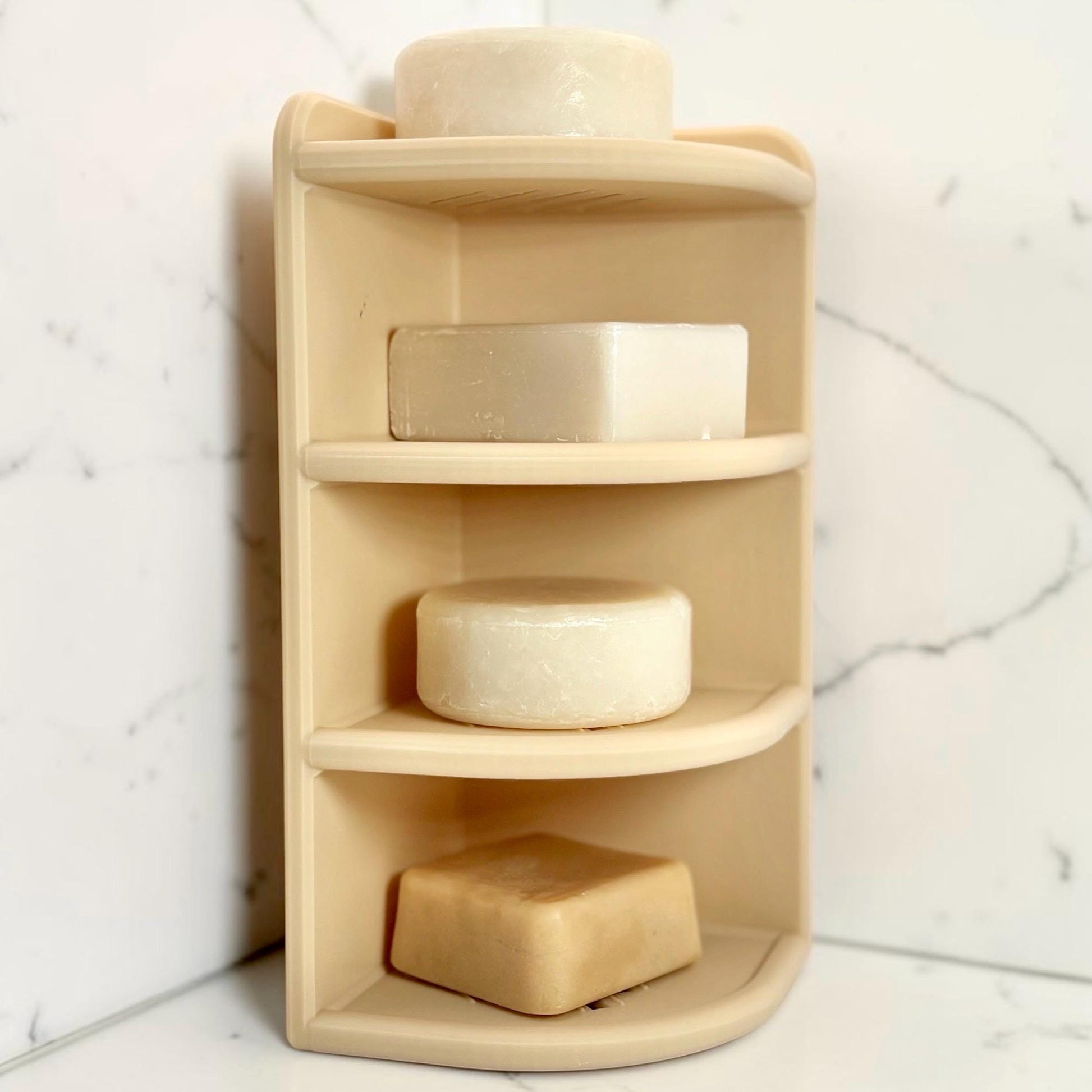 beige corner shelf with soap bars against a marble wall