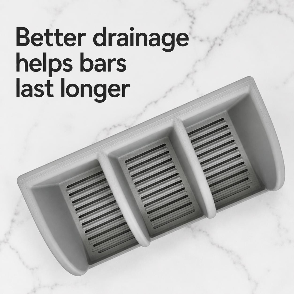 Gray soap dish with text 'Better drainage helps bars last longer' on a marble background