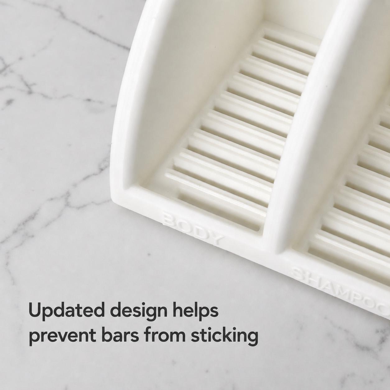White soap dish with slotted design on a marble surface