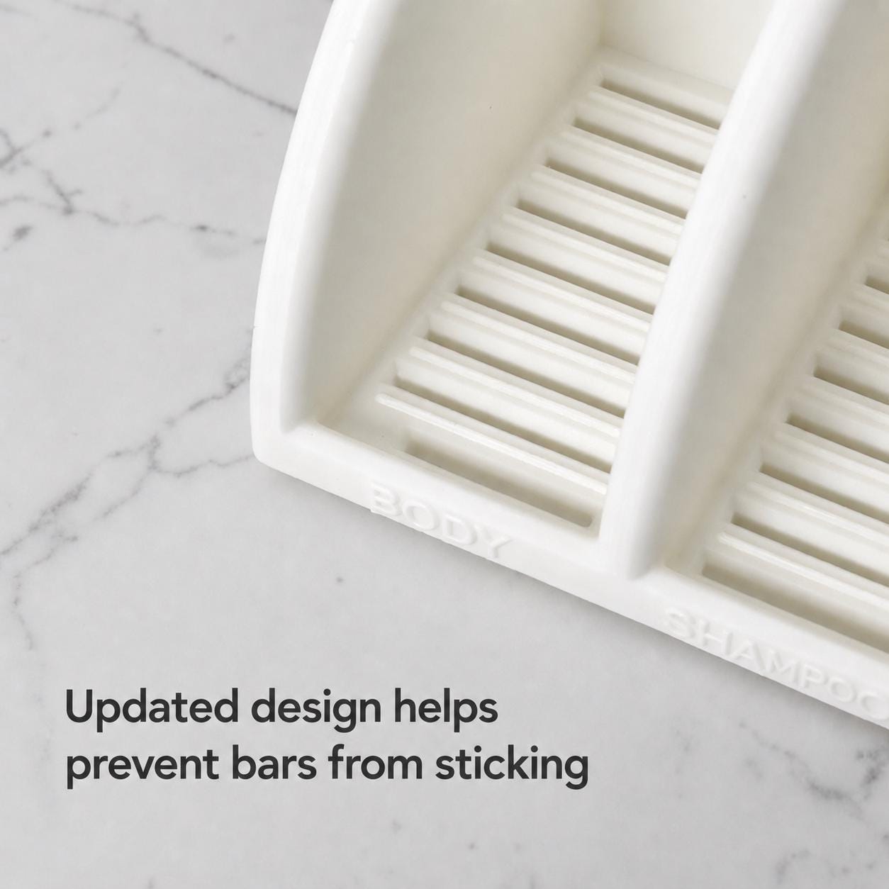 White soap dish on a marble surface with text about preventing soap bars from sticking.