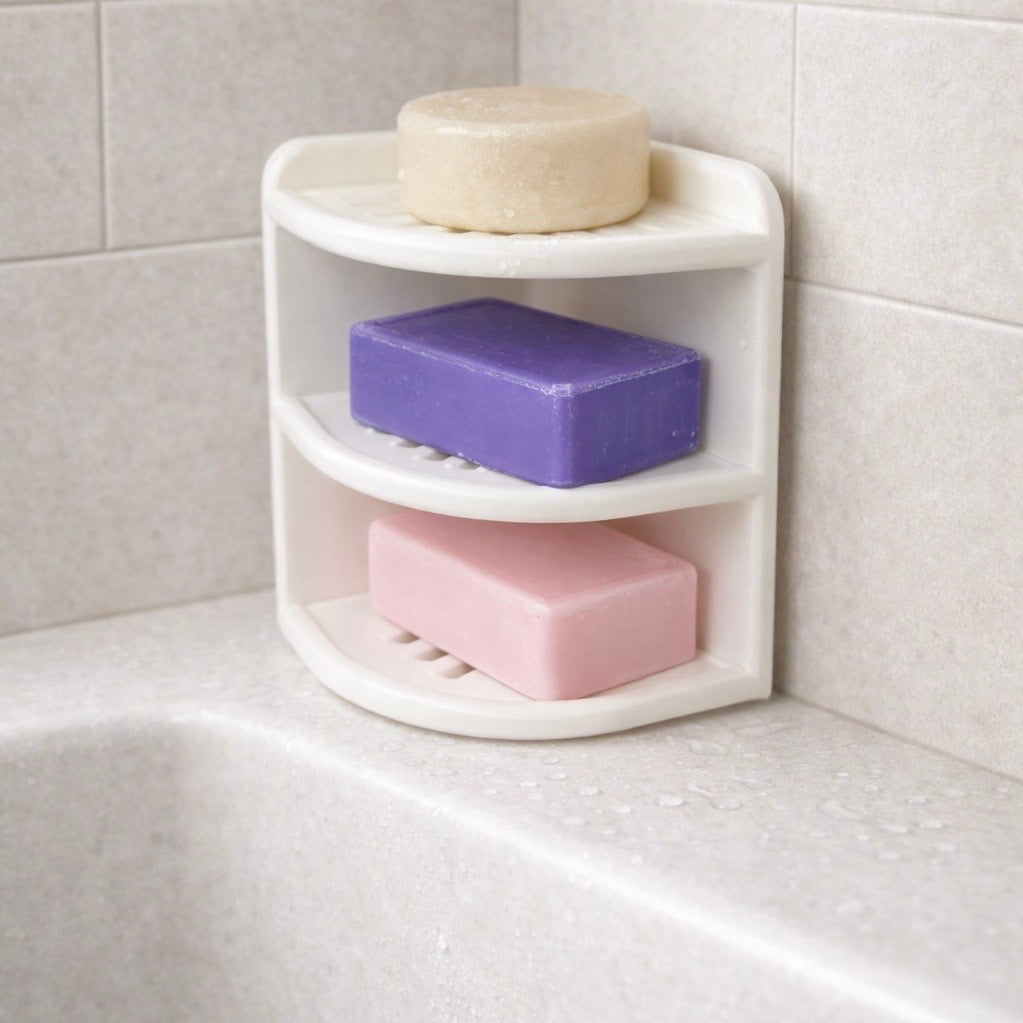 White Corner soap holder with three bars of soap on a tiled bathroom wall.